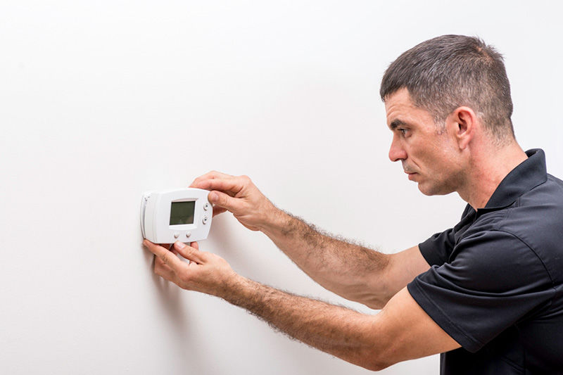 Man fixing a Thermostat
