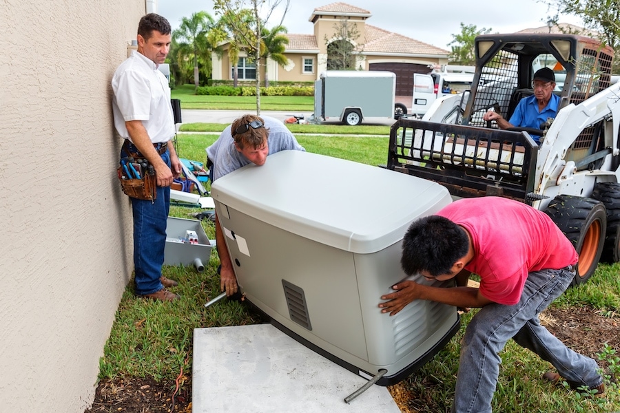 HVAC technicians installing a whole house generator.