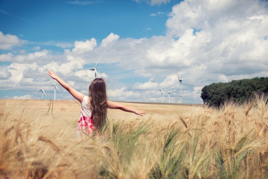 Girl standing in a field in Saskatoon, SK, on a windy day.